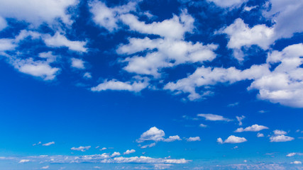 Bright blue sky with white varied clouds