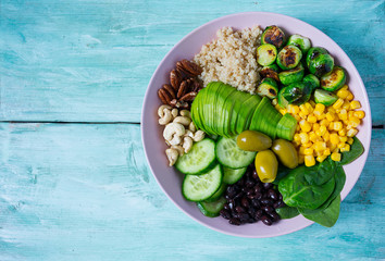 budha bowl with brussel cabbage, corn, quinoa, cucumbers,nuts, avocado and spinach