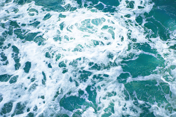 bright blue surface of ocean water with waves, and white foam, background, texture