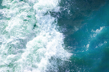 Fototapeta na wymiar bright blue surface of ocean water with waves, spray and white foam, background, texture