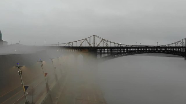 Slow aerial push through the fog toward Eads Bridge in St. Louis, Missouri.