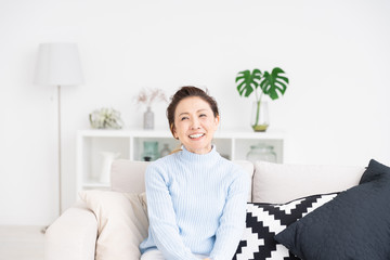 部屋でリラックスするシニア女性