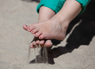 Woman's feet and toes playing in sand