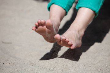 Woman's feet and toes playing in sand