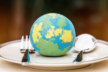 Globe model placed on plate with fork spoon for serve menu in famous hotels. International cuisine...