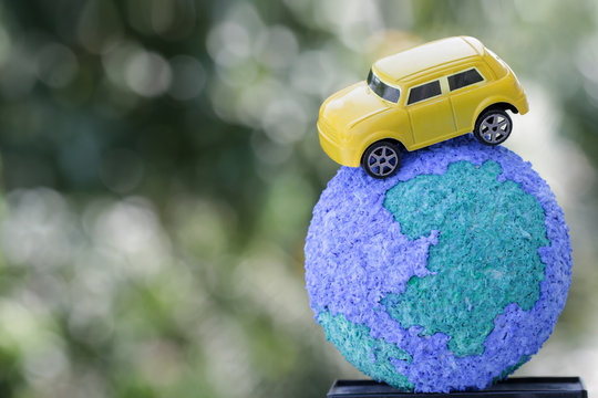 Eco Friendly Save World Concept. Yellow Car On Paper Mache Craft Earth Globe Natural Background. Ideas Of Earth Maintenance By Reducing Energy Consumption, Travel Around The World