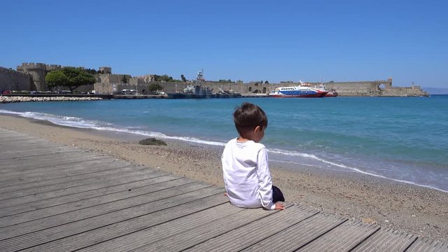 Rhodes, Greece - 21st of April 2018: 4K War ship lays against the ancient fortress walls