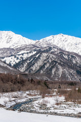 Fototapeta na wymiar 白馬村の雪山と青空の雪景色