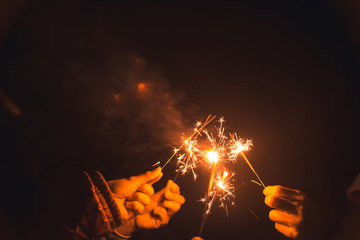 A group of friends who held a party and smiled happily at sparklers.