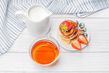 Healthy breakfast. Tea and delicious pancakes, with fresh blueberries, strawberries