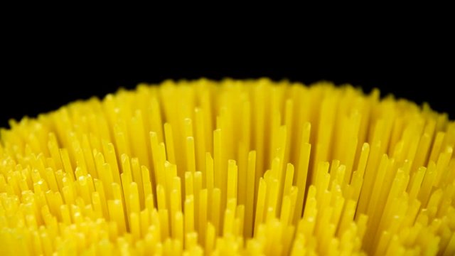 Spaghetti rotating on black background in 4K resolution