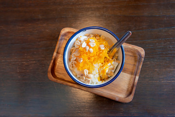 Ice cream coconut milk with in an antique cup style on wooden table the delicious  Thai fusion dessert