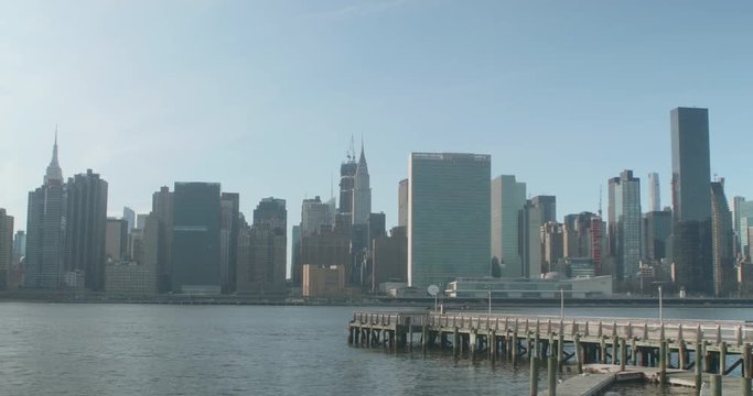Manhattan skyline from Long Island City waterfront with a dock in the foreground.