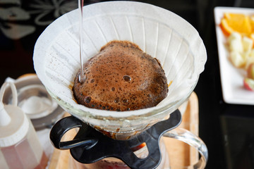 drip coffee barista pouring water on filtered brewing / make cup hand drip coffe in glass jar