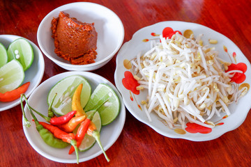 Side dish with lime chilli curry and bean sprout for garnish noodle soup asia food on the table