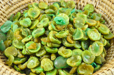 Cooked baked salt broad beans in basket isolated on white background