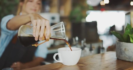 Close up of barista pouring coffee from glass carafe