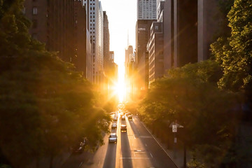 Sunlight shines on the buildings and cars along 42nd Street through Midtown Manhattan around the...