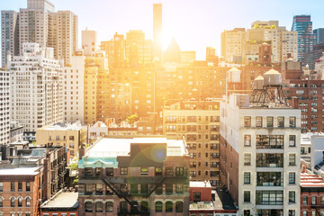 Sunlight shining behind the skyline buildings of Midtown Manhattan in New York City