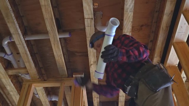 Men plumber glued plastic toilet white pipe in close up shot