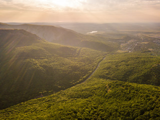 bright summer sunshine in the high mountains covered with forest b