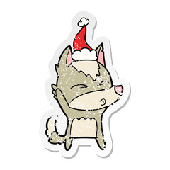 distressed sticker cartoon of a wolf whistling wearing santa hat