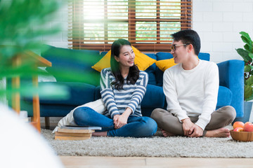 sweet lovey asian family couple sit talk good conversation on sofa in living room house background