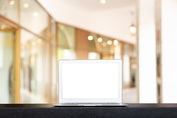 Mock up of modern computer or laptop with Blurred The walk way or corridor in the building for shopping.