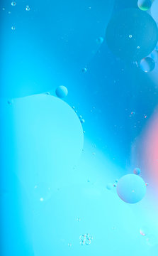 Blurred abstract background. Image of abstract blue and pink circles and drops of different sizes. Cropped shot, vertical, blurred, free space, nobody