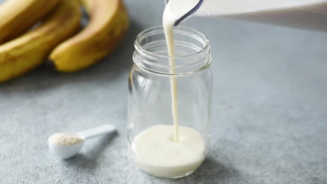 Pouring protein smoothie in glass. Food preparation footage. Concept of weight loss, sport, fitness, dieting and healthy lifestyle
