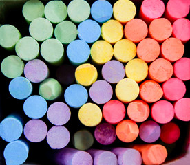 Colorful chalk in box for drawing on chalkboard on top view