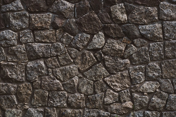 background from a wall erected from roughly treated gray granite stones