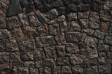 background from a wall erected from roughly treated gray granite stones