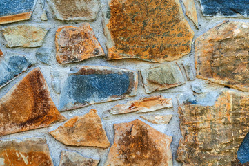 background from a wall erected from roughly treated brown and gray granite stones.