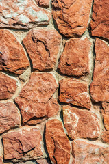 background from the old darkened wall with granite brown roughly processed stones close-up