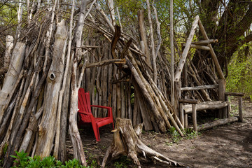 Teepee fort and bench hand made of woodland logs and sticks in a Toronto Park urban forest beside the Humber river Canada