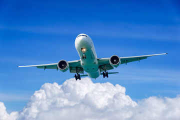 Passenger plane in flight. Aircraft fly high in the sky above the clouds. Front view of airplane.