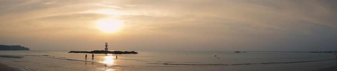Fototapeta premium Image of small lighthouse against a tropical ocean sunset and smooth water at Khao Lak Beach in Phang Nga,Thailand. English translate;Khao Lak light beacon..