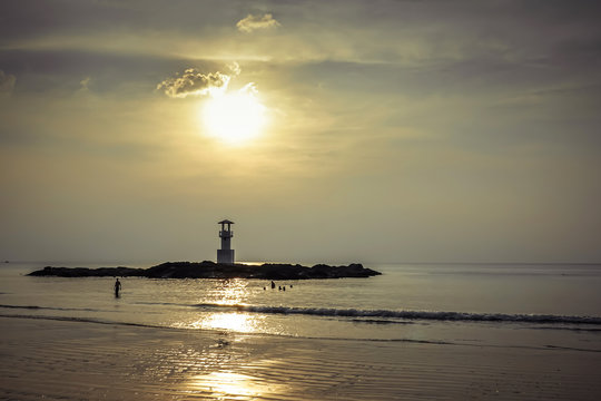 Image of small lighthouse against a tropical ocean sunset and smooth water at Khao Lak Beach in Phang Nga,Thailand. English translate;Khao Lak light beacon..