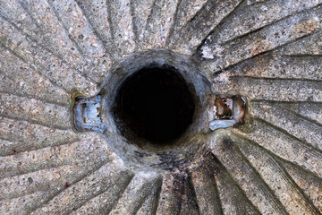 A top symmetrical view of an old millstone used to grind corn or wheat at the gristmill many years ago at Historic Yates Mill County Park in Raleigh North Carolina. - obrazy, fototapety, plakaty