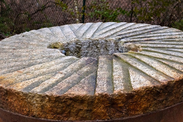 An old millstone used to grind corn or wheat at the gristmill many years ago at Historic Yates Mill County Park in Raleigh North Carolina.