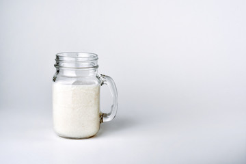 Protein cocktail, smoothie with milk, vanilla in a glass jar with straws.
