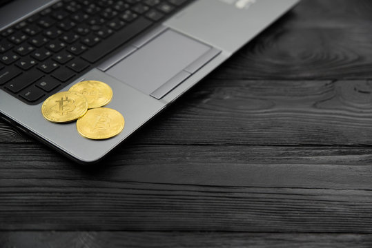 Golden bitcoin on the laptop keyboard.