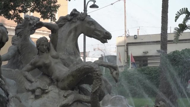 Slow motion water jets spraying onto a concrete sculpture at Fontana di Proserpina in Catania, Italy