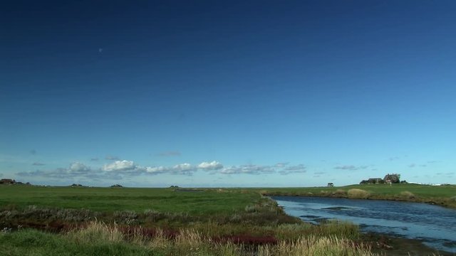 Blue sky with moon over marshland on Holm Hooge at the North Sea, Germany.