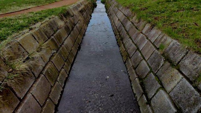 Low angle follow shot of a ditch during daytime