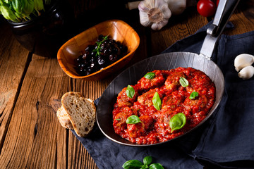 Baked mini meatballs in tomato sauce with basil