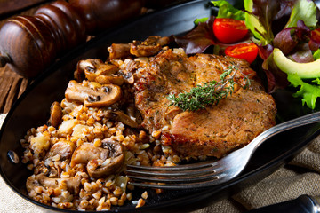 Pork steak with mushrooms and buckwheat groats and mango salad