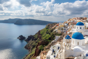 Traditional white houses and churches with blue domes over the Caldera, Santorini, Oia, Greece. - obrazy, fototapety, plakaty