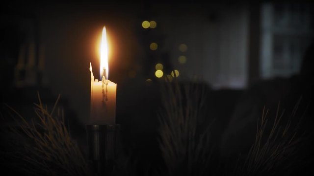 A single lit candle in a cozy warm environment at christmas time.